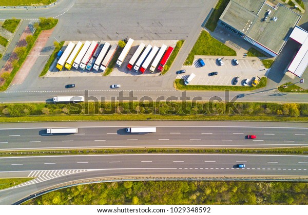 Aerial view of highway rest area with\
restaurant and large car park for cars and trucks. D5 motorway in\
west Bohemia, Czech republic, European union. Top view of highway\
infrastructure.