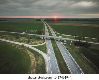 Aerial view of a highway with a road bridge during a summer sunset. - Shutterstock ID 1417461944