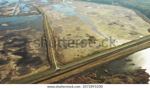 Aerial View Of Highway Road Through Ponds Autumn\
Landscape. Truck Tractor Unit Prime Mover Traction Unit In Motion\
On Freeway. Business Transportation. Top View, Drone View, Bird\'s\
Eye View.