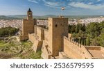 Aerial view of the historic Alcazaba fortress in Antequera city in Andalusia, Spain. Flying over the old town, Catholic churches, historic buildings and the medieval castle