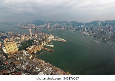 Aerial View Of Hong Kong & Kowloon ( Tsim Sha Tsui ) On A Gloomy Cloudy Day With City Skyline Of Crowded Skyscrapers By Victoria Harbour & Ships Across The Busy Seaport~Beautiful Cityscape Of Hongkong