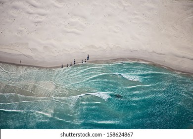 Aerial view of horses trotting on Noordhoek Beach in early morning. Riders are often spotted exercising their horses on this beautiful Cape Town beach.