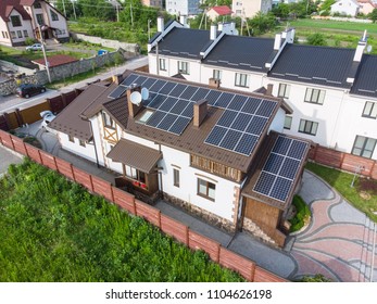 aerial view of house with solar roof. clean energy - Shutterstock ID 1104626198
