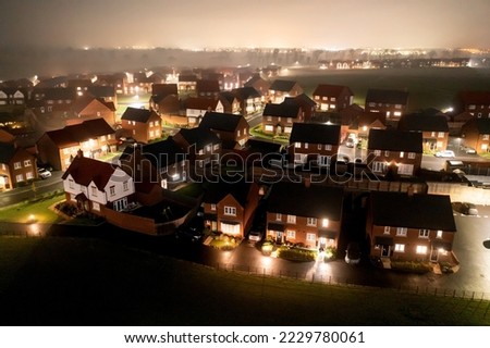 Aerial view of houses in England at night  - Drone view of a new estate with typical British houses and fog mist - Real estate and buildings concepts in UK