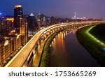 Aerial view of HuanDong Boulevard, an elevated expressway along Keelung River in Nangang, Taipei City, and 101 Tower standing out among crowded buildings in Xinyi District under beautiful twilight sky