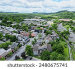 aerial view of hudson, new york (small hudson valley town city downtown historic district) mountains catskills ny travel destination main street with hills clouds cars tree matter
