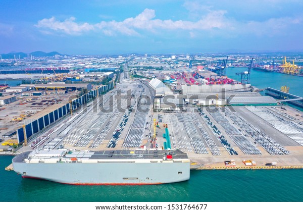Aerial view of the\
huge ro-ro ship loading new cars. Automotive container carriers\
oversea services. Transportation business for prefabricated cars by\
sea freight.