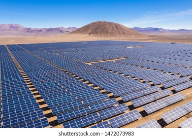Aerial view of hundreds solar energy modules or panels rows along the dry lands at Atacama Desert, Chile. Huge Photovoltaic PV Plant in the middle of the desert from an aerial drone point of view