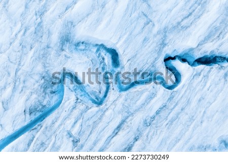 An aerial view of an iceberg and river. Winter landscape from a drone. View of the moraines. Landscape from the air. River on a moraine. 