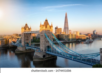 Aerial View To The Iconic Tower Bridge And Skyline Of London, UK, During Early Morning Sunrise With Golden Colors