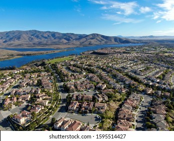 Aerial view of identical residential subdivision house with big lake and mountain on the background during sunny day in Chula Vista, California, USA. - Shutterstock ID 1595514427
