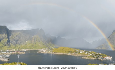 Aerial view of idyllic rainbows over Olstind mountain and fishermen cabins by the sea, Sakrisoy, Reine, Lofoten Islands, Nordland, Norway, Scandinavia, Europe - Powered by Shutterstock