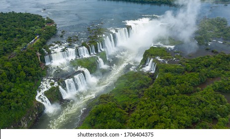 Aerial View Of Iguazu Falls, Monumental Waterfall System On Iguazu River Surrounded By Lush Green Jungle - Landscape Panorama Of Brazil/Argentina Border, South America