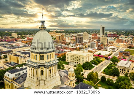 Aerial view of the Illinois State Capitol dome and Springfield skyline under a dramatic sunset. Springfield is the capital of the U.S. state of Illinois and the county seat of Sangamon County