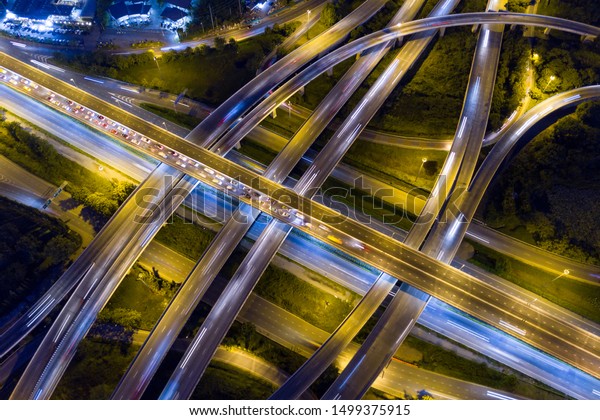 Aerial view of
illuminated road interchange or highway intersection with busy
urban traffic speeding on the road at night. Junction network of
transportation taken by
drone.