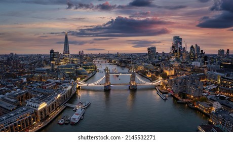 Aerial view of the illuminated Tower Bridge and London skyline during dusk - Shutterstock ID 2145532271