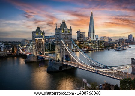 Aerial view to the illuminated Tower Bridge and skyline of London, UK, just after sunset