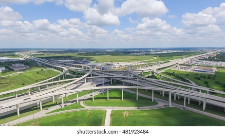 Aerial view Interstate 10 or Katy freeway with massive intersection, stack interchange, elevated road junction overpass in daytime with cloud blue sky. Aerial metropolitan area of Katy, Texas, US.