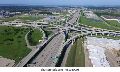 Aerial view Interstate 10 or Katy freeway with massive intersection, stack interchange, elevated road junction overpass in daytime with clear blue sky. Aerial metropolitan area of Katy, Texas, US.