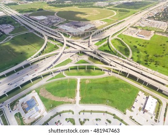 Aerial view Interstate 10 or Katy freeway with massive intersection, stack interchange, elevated road junction overpass in daytime. Nightly degree vertical view metropolitan area of Katy, Texas, US.