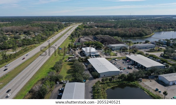 Aerial view of\
Interstate 75 southwest Florida near north Fort Myers. Just a few\
of the many warehouses in the area. Shows how industry is moving in\
and nature moving out.