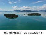 Aerial view of islands and distant mountains in Flathead Lake, Montana on calm summer morning.