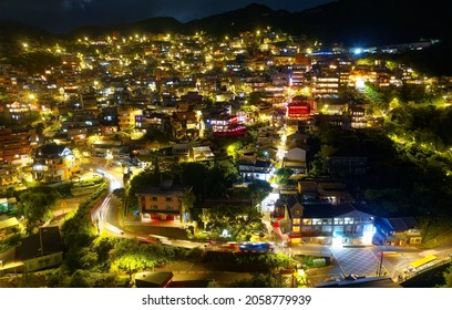Aerial view of Jiufen Old Town at night, a famous tourist destination in Ruifang  District, New Taipei City, Taiwan, with houses sprawling on the mountainside and the lights dazzling in the dark