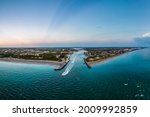 aerial view of jupiter inlet along florida atlantic coast in early morning with fishing boats headed out