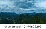 Aerial view Kabut Pelangi Waterfall in East Java. The waterfall stream flows into the mountain gorge in a long path.Above is the residence of the villagers. Abundance of forests on the green mountain
