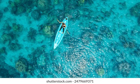 Aerial view of a kayak in the blue sea .Woman kayaking She does water sports activities. - Powered by Shutterstock