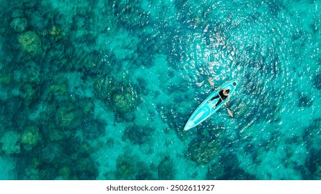 Aerial view of a kayak in the blue sea .Woman kayaking She does water sports activities.