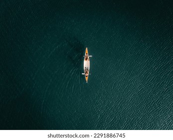 aerial view of a kayak with a boy and a girl on board calmly sailing alone in silence through the waters of the lake, tarawera lake, new zealand - Powered by Shutterstock