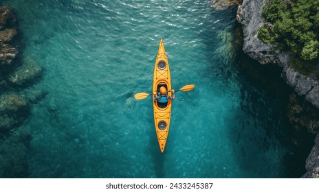 Aerial View of a Kayaker on Clear Waters, Top-down perspective of a kayaker in a yellow kayak navigating the crystalline blue waters - Powered by Shutterstock
