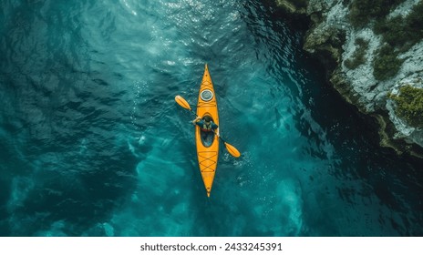 Aerial View of a Kayaker on Clear Waters, Top-down perspective of a kayaker in a yellow kayak navigating the crystalline blue waters - Powered by Shutterstock