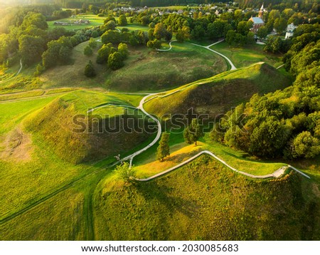 Similar – A tranquil aerial view of a lush golf course fairway, bathed in the warm glow of sunset. Ideal for themes of relaxation, nature, and sports, this image captures the peaceful beauty of the golfing experience.