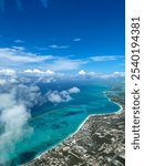 Aerial view of Key West, Florida, with vibrant turquoise waters, coral reefs, and sandy beaches. White clouds drift over the coastline, while the clear blue sky highlights the island’s tropical beauty