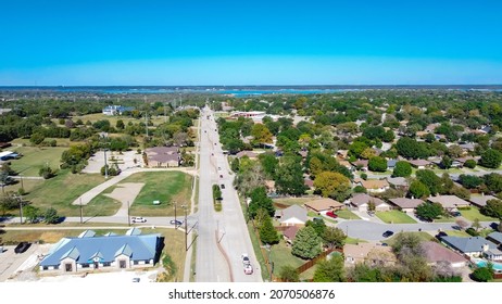 Aerial view Kimball Avenue toward Grapevine Lake, Texas separating the residential neighborhood and business park. Lakeside houses and commercial building along the service road with power lines