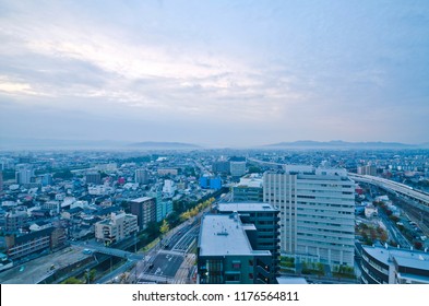 Aerial View Of Kumamoto Downtown (before Earthquake) With A Beautiful City Skyline Of High Rise Skyscrapers, A High Speed Bullet Train Traveling On Railway.