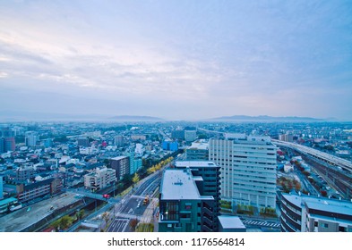 Aerial View Of Kumamoto Downtown (before Earthquake) With A Beautiful City Skyline Of High Rise Skyscrapers, A High Speed Bullet Train Traveling On Railway.