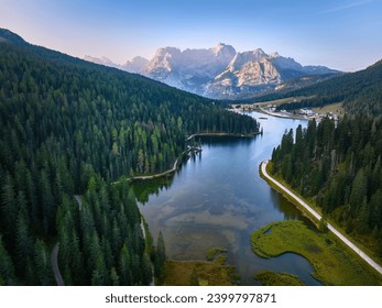 Aerial view of Lago di Misurina  and the panorama of the Dolomites in background. Sunny morning, blue sky, view across the lake and hiking paths. 