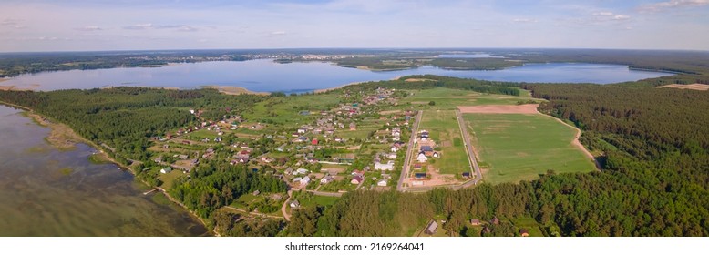 Aerial view of lake and small village. Village near the lake. Aerial view of the village and trees on the shore of lake. Nature background.