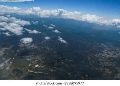 Aerial view of the land from the airplane with clouds - Powered by Shutterstock