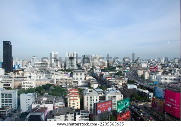 Aerial view landscape cityscape of bangkok city\
and high building tower condominium with thai people driving riding\
biking on street and traffic road busy jam on August 25, 2022 in\
Bangkok, Thailand