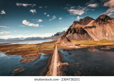 Aerial view landscape of Vestrahorn mountain with dirt road on black sand beach in Atlantic ocean on Stokksnes peninsula at Iceland