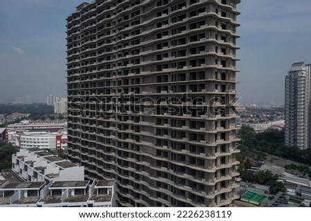 Aerial view of large abandoned concrete shell of residential high-rise real estate and construction development. Close  up of structure.