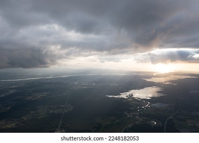  an aerial view of a large body of water under a cloudy sky with sun shining through the clouds and a river running through the water below it, and a city below the water below. .  - Powered by Shutterstock
