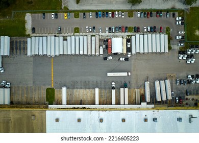 Aerial View Of Large Commercial Loading Bay With Many Delivery Trucks Unloading And Uploading Retail Goods For Nationwide Distribution. Global Economy Concept