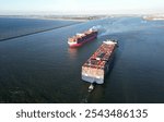 Aerial view of a large containership and tugboats approaching the port of Rotterdam, The Netherlands