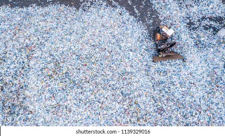 Aerial view large garbage pile, Garbage plastic bottle pile in trash dump, Waste from household in waste, Excavator machine is working, Ecosystem and healthy environment concepts and background.