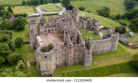 Aerial View Of A Large Medieval Castle Showing The Turrets, Walls And Moat (Raglan Castle, South Wales)